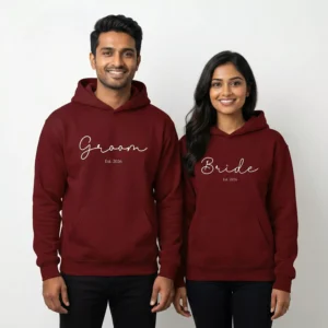 Bride and groom wearing maroon personalized matching hoodies with custom Est year wedding design